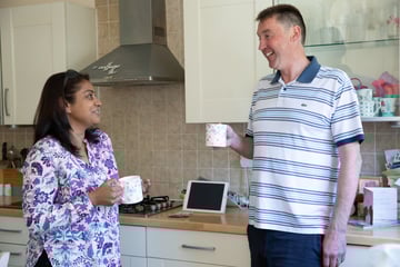 Two neighbours having a cup of tea in the kitchen